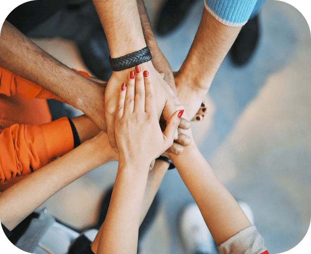 A group of people holding hands in the middle of a circle.