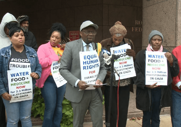 A group of people holding signs in front of a building.