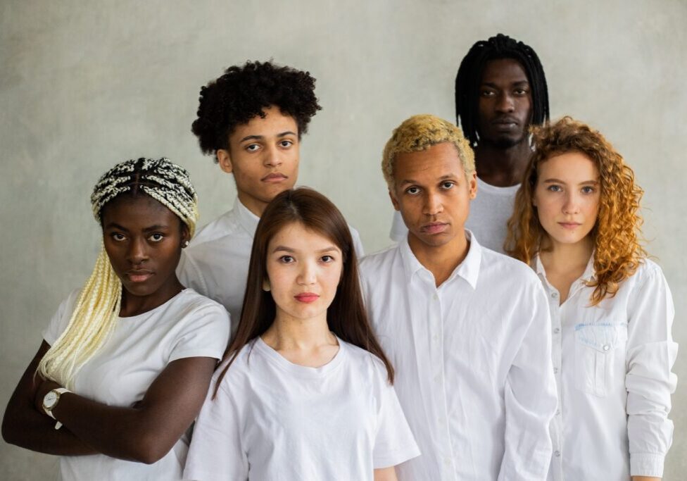 A group of people standing together in white shirts.